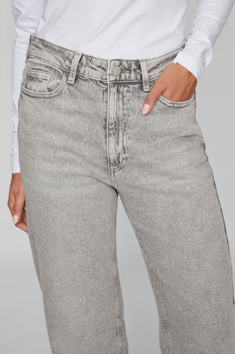 Lichtgrijze straight jeans van VILA, met hand in de zak en gedragen met een wit shirt met lange mouwen.
