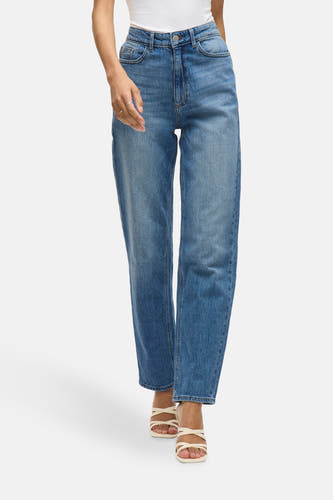 Jean droit en denim bleu de VILA, légèrement lavé et porté avec des sandales blanches.