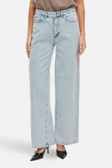 Lichtblauwe denim jeans wide van Vila, met hoge taille en gecombineerd met zwarte hakken.
