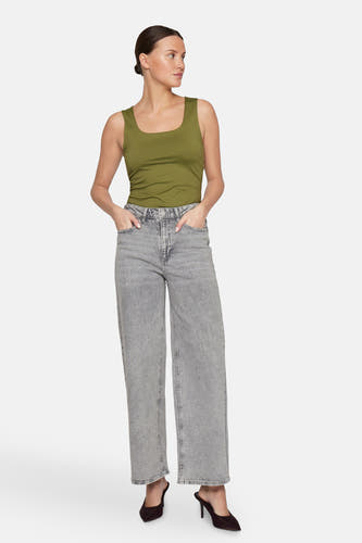 Jean décontracté de denim gris clair de VILA, avec poches et associé à une chemise verte et des baskets.