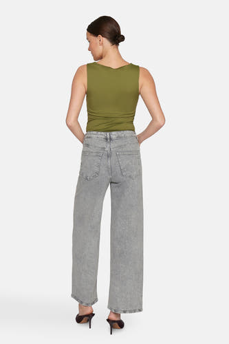 Jean clair gris large de VILA, avec une taille haute et des poches arrière, porté avec un haut vert olive et des baskets.