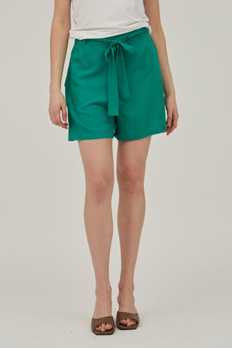 Short vert de VILA, avec une ceinture à passants et combiné à un shirt blanc.