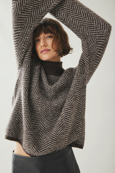Pull-over marron avec col montant de VILA®, à motif chevron et porté avec une jupe noire.