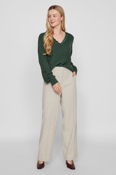 T-shirt V-hals vert deilaILAILA, avec une fin fin fin la la ligne du hals, associé à un pantalon beige et des chaussures marron.