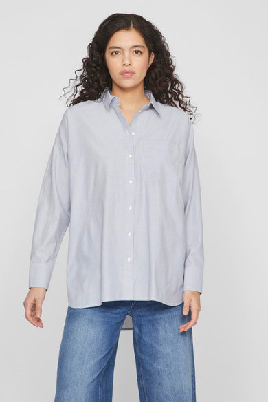 Blauw gestreept overhemd met lange mouwen van VILA, met een borstzak en gedragen met een blauwe jeans.
