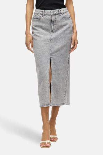 Grijze rok 3/4 van VILA, met een split aan de voorkant en gedragen met witte slippers.
