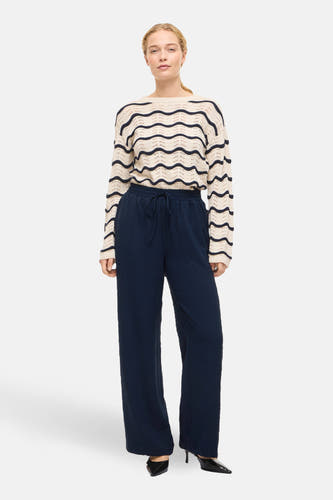 Blauwe colorbroek van VILA®, met een elastische tailleband en wijde pijpen, gedragen met een gestreepte trui en zwarte hakken.
