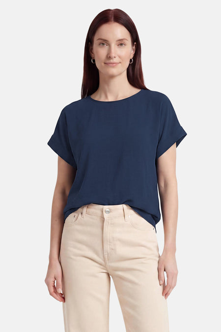 T-shirt bleu de VILA® à manches courtes retroussées, légèrement texturé, dos, porté avec un pantalon beige.