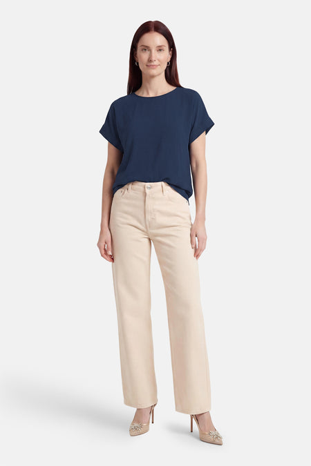 Blauw T-shirt van VILA® met korte mouwen en ronde hals, gedragen met een beige broek en hakken.