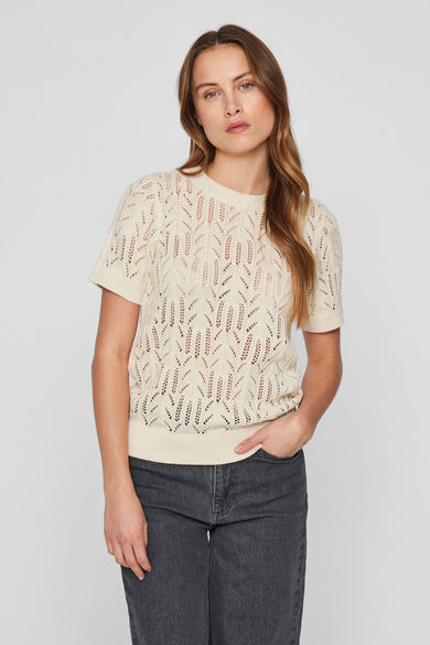 Ecru trui met ronde hals van VILA®, met ajourpatroon en gedragen met een grijze jeans.
