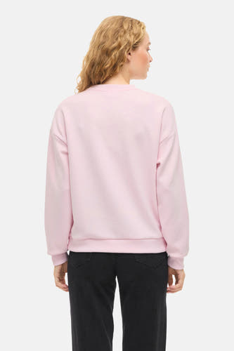 Gilet rose de VILA, avec des manches longues et un col rond, porté avec une jupe noire.