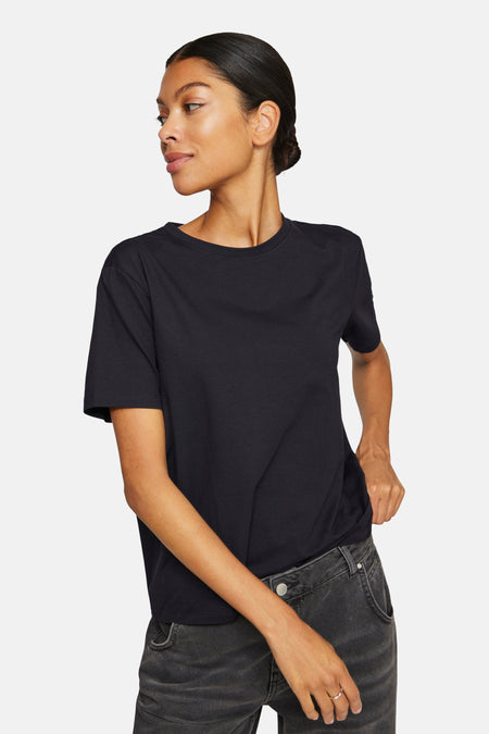 Zwart T-shirt met korte mouwen van VILA®, gedragen met grijze jeans en losjes ingestopt.