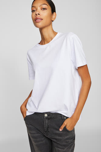 Wit T-shirt met korte mouwen van VILA®, gedragen met donkere jeans en handen in de zakken.

