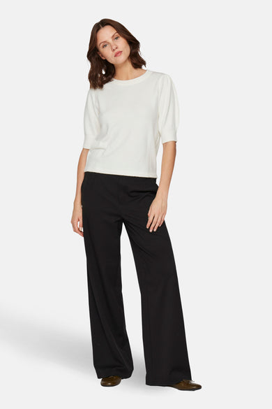 Witte trui met ronde hals van VILA, met korte pofmouwen, gedragen met zwarte, wijde pantalon.