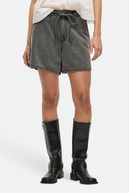Short gris de Vila, avec un détail de nœud, associé à des bottes en cuir noir.