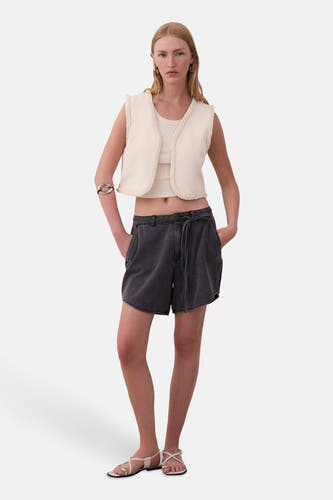 Grijze short van VILA, met een hoge taille en een strikceintuur, gecombineerd met een top en vest.
