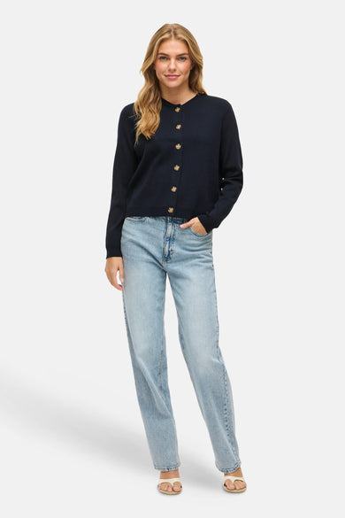 Blauw vest van VILA®, met knopen en gedragen met lichtblauwe jeans en teenslippers.
