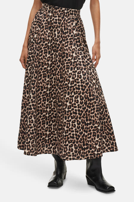 Lange rok in bruine leopardprint van VILA, met een elastische tailleband en zwarte laarzen.
