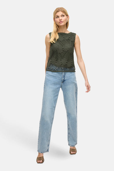 Blouse verte sans manches de VILA, avec imprimé floral, associée à des jeans bleus et des bottes marron.