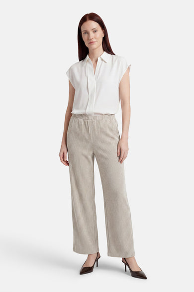 Beige gestreepte broek van VILA® met wijde pijpen en elastische tailleband, gedragen met witte blouse en bruine hakken.