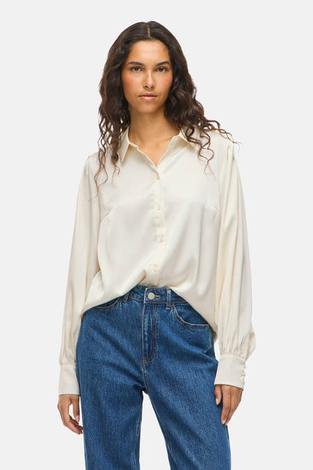 Wit, lang mouwen hemd van VILA®, gecombineerd met een donkerblauwe jeans.
