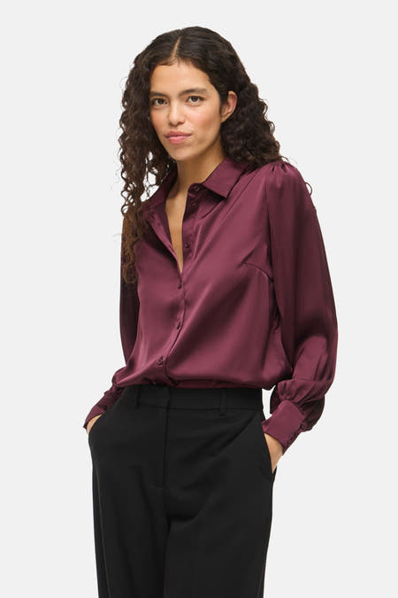 Bordeauxkleurig hemd met lange mouwen van VILA®, met een glanzende afwerking en zwarte pantalon.
