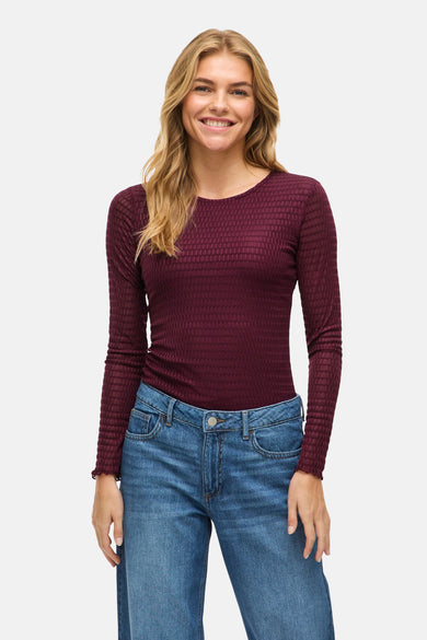 Paarse T-shirt met lange mouwen van VILA® met een geweven textuur en gedragen met blauwe jeans.
