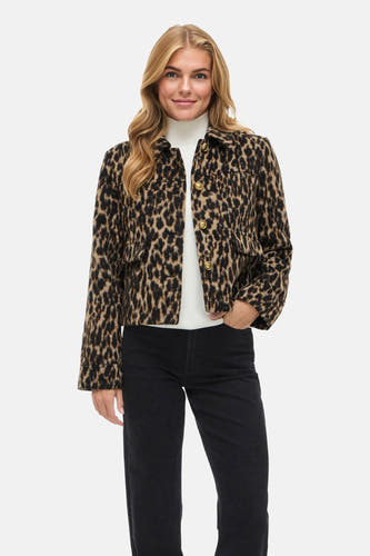 Bruine korte jas van VILA, met een luipaardprint en gouden knopen, gedragen met een witte coltrui en zwarte jeans.
