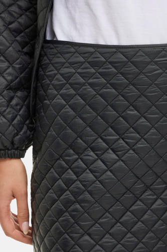 Zwarte korte rok van VILA®, met gewatteerd ruitpatroon en zichtbare hand aan de zijkant, close-up.

