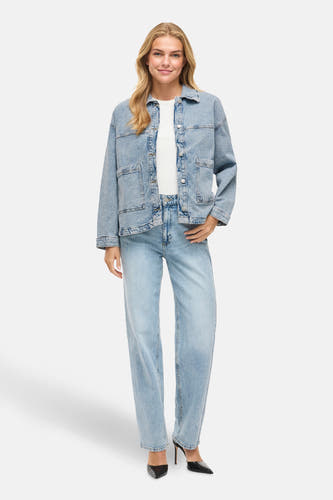 Jeansjas van lichtblauw denim van VILA®, met knoopsluiting, zakken en lange mouwen, gecombineerd met een wit shirt en blauwe jeans.