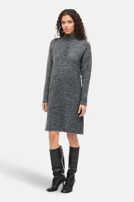 Vêtement gris à longues manches de VILA®, porté avec des bottes noires hautes.