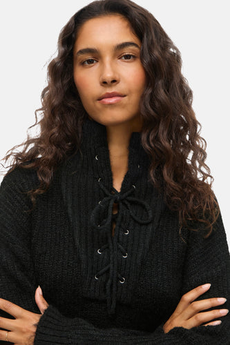 Zwarte trui van VILA met vetersluiting en een hoge kraag.