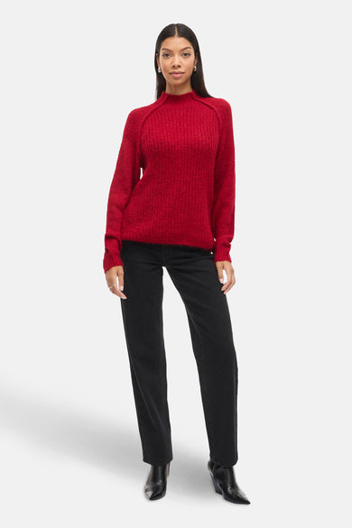 Pull rouge à col rond de VILA®, associé à un jean noir et des bottines noires.