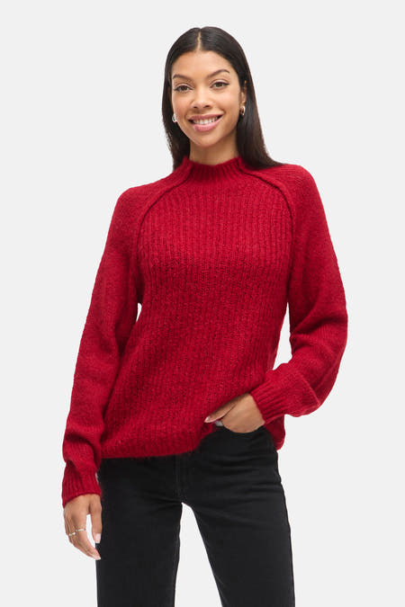 Rode trui met ronde hals van VILA®, getextureerd en gedragen met een zwarte jeans.
