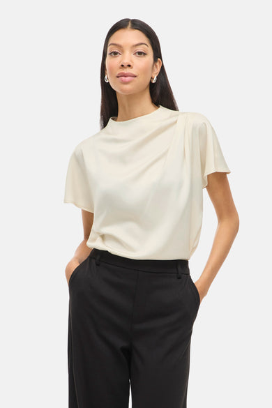 Ecru blouse met korte mouwen van VILA®, met gedrapeerde halslijn en gecombineerd met een zwarte pantalon.
