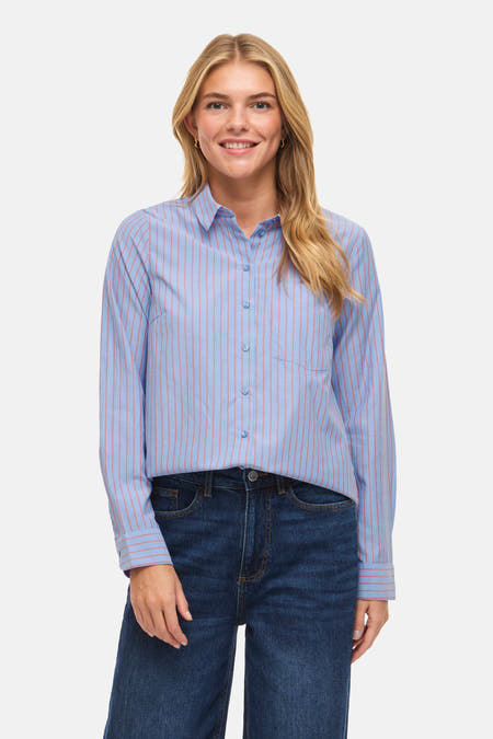 Blauw gestreept overhemd met lange mouwen van VILA, met een borstzak, gecombineerd met donkere jeans.
