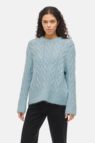 T-shirt bleu avec col rond de VILA®, motif côtelé et porté avec des jeans noirs et des ballerines.