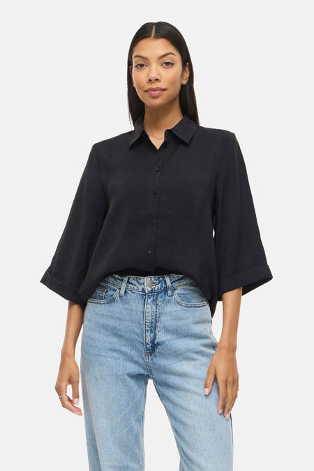 Zwart hemd met korte mouwen van VILA, gedragen met een lichte denim jeans.