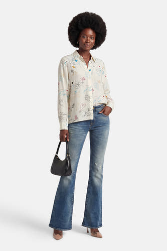 Multikleurig overhemd met lange mouwen van VILA, versierd met speelse illustraties en gedragen met blauwe jeans en een zwarte tas.
