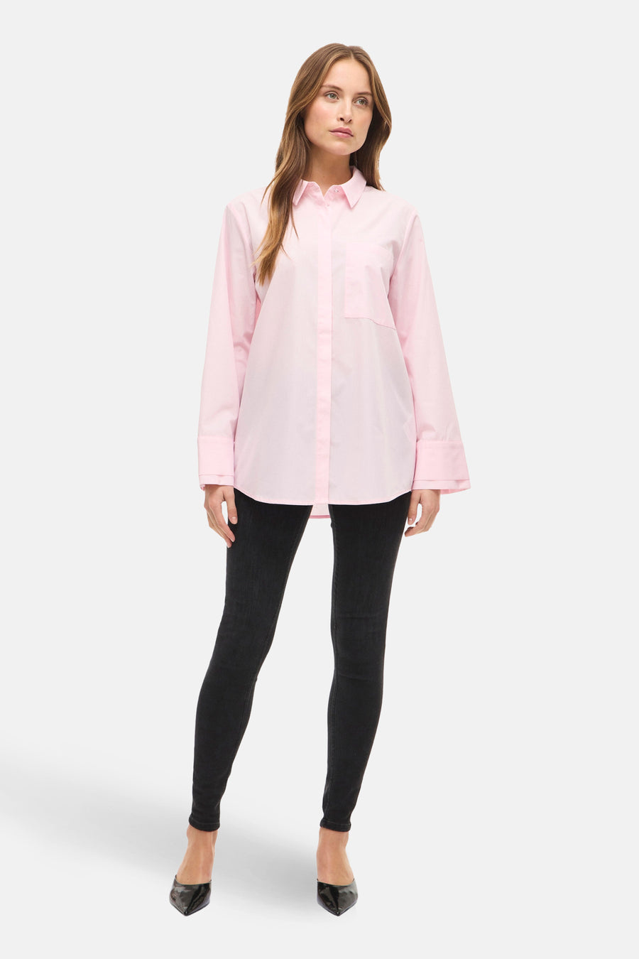 Roze overhemd met lange mouwen van VILA®, gedragen met zwarte jeans en hoge hakken.