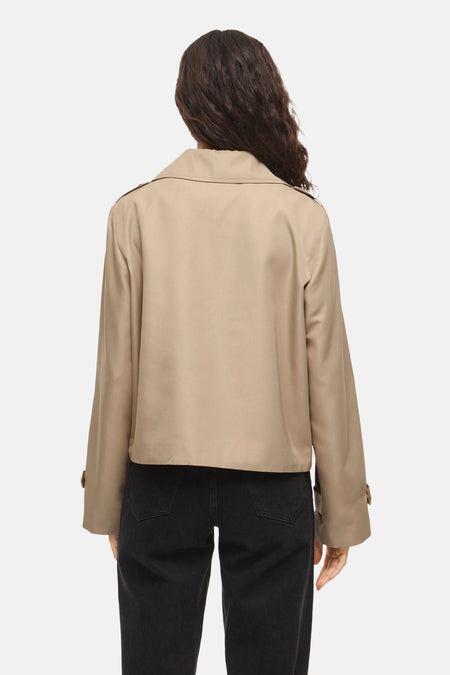 Beige korte jas van VILA® met lange mouwen, gezien van achteren, gecombineerd met een zwarte jeans.
