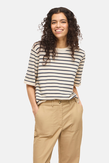 Beige T-shirt met korte mouwen van VILA®, met een gestreept patroon en gedragen met een kaki broek.
