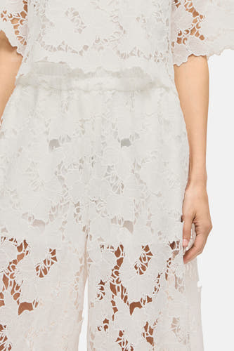Pantalon blanc de VILA®, avec imprimé floral et détails ouverts.