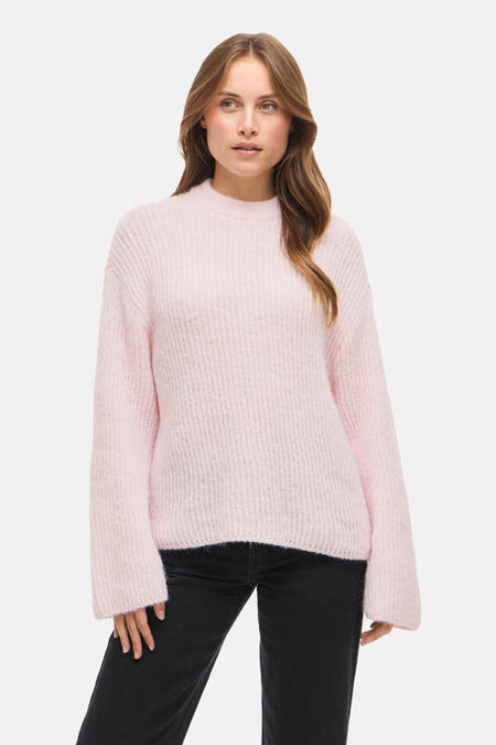 T-shirt rose avec col rond de VILA, porté avec des jeans noirs et des bottines noires.