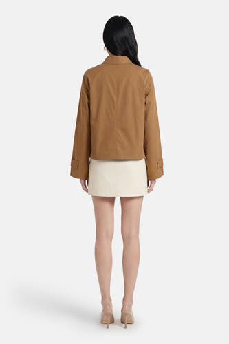 Manteau court beige de VILA®, vu de dos, combiné avec une jupe de couleur crème et des escarpins beiges.