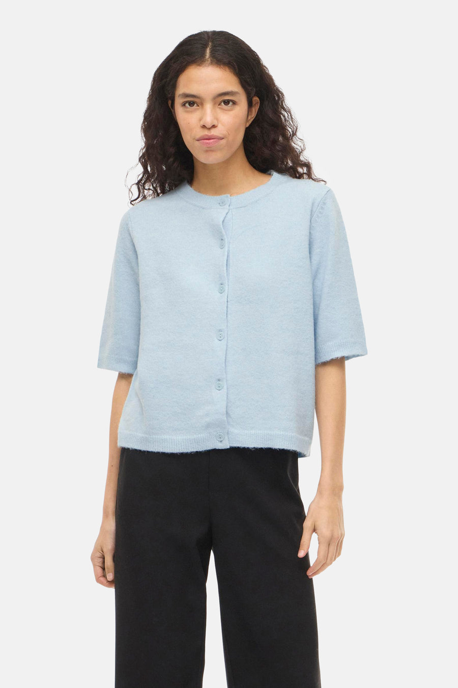 Blauw gilet van VILA®, met korte mouwen en knoopsluiting, gedragen met een zwarte broek.
