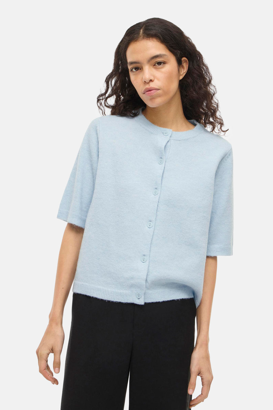 Blauw vest van VILA® met korte mouwen en knoopsluiting, gedragen over een zwarte broek.