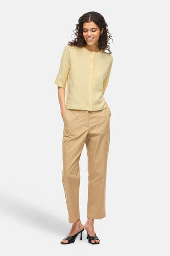 Gele gilet van VILA®, gedragen met kaki broek en zwarte open schoenen.