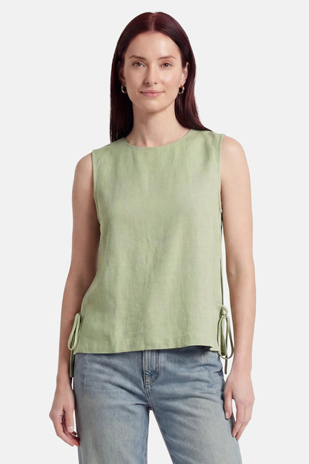Groene mouwloze blouse van VILA® met zijdelingse strikjes, gedragen op een spijkerbroek.