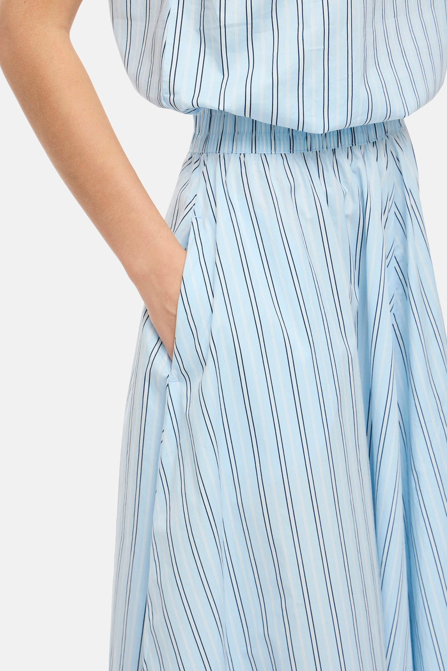 Jupe bleue de VILA®, avec motif rayé et main dans la poche.